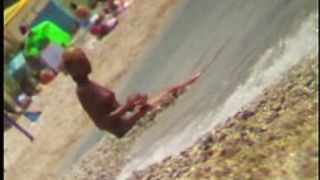 Sexy blonde chick is sitting naked by the sea and relaxing