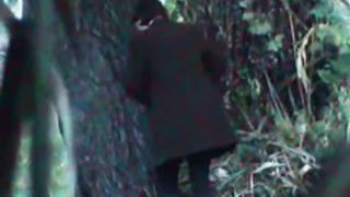 A business woman goes to take a piss in the autumn forest