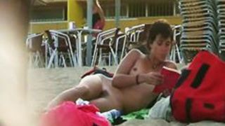 Short haired sweetie filmed on a nudist beach