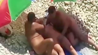 Threesome sex fun on public beach caught on voyeur cam