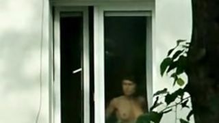 Hot undressed brunette is spied in the window