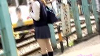 Teenage oriental hoe is waiting for the bus during street sharking action