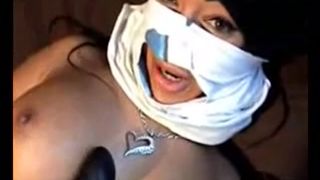 Masked Arabic lady plays with a big black dildo on tape