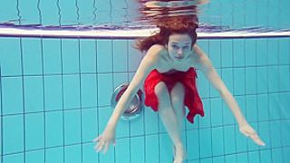 Red Dressed teen swimming with her eyes opened