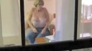 Naked mature woman voyeured masturbating through window