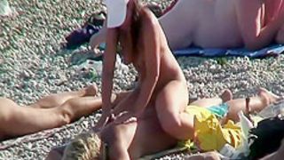 Daughter massages mother on a beach