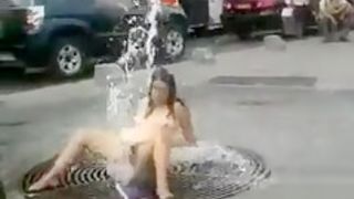 Nude chick washing her pussy on the street