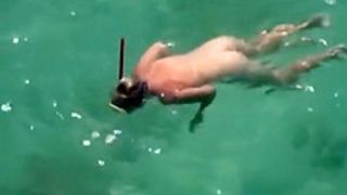 Nudist woman swimming in the water