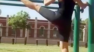Flexible woman in spandex stretches in the park